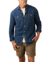 Man wearing a blue denim shirt and brown shorts on a white background